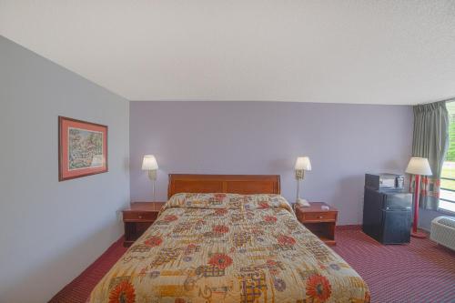 a hotel room with a bed and two night stands at Masters Inn Selma Smithfield I-95 By OYO in Selma