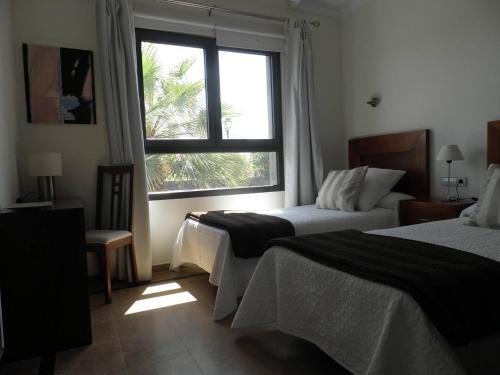 Habitación de hotel con 2 camas y ventana en Villa La Carabela 35, en Playa Blanca