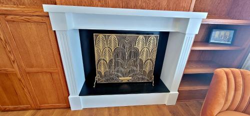a fireplace in a living room with a chair at Retro Inn at Mesa Verde in Cortez