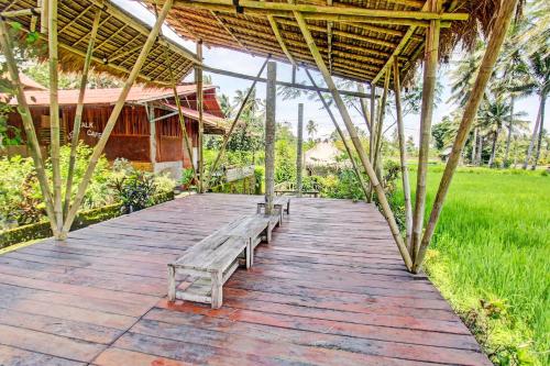 a wooden walkway with benches sitting on it at Hotel O Samalas Syariah Homestay Near SDN TANAK BEAK in Labuan Lombok