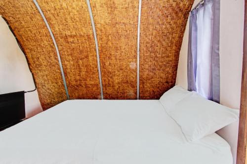 a bed with a head board and a window at Hotel O Samalas Syariah Homestay Near SDN TANAK BEAK in Labuan Lombok