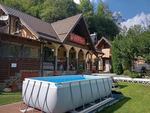 ein großes weißes Boot vor einem Haus in der Unterkunft Casa Rania si Ayan Sătic Rucăr in Ciocanu