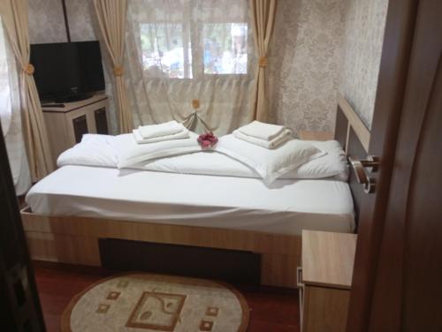 ein Schlafzimmer mit einem Bett mit weißen Laken und einem Fenster in der Unterkunft Casa Rania si Ayan Sătic Rucăr in Ciocanu