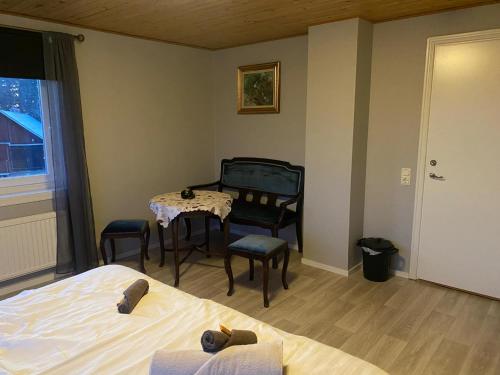 a bedroom with a table and chairs and a bed at Skräpplinge gård in Mörlunda
