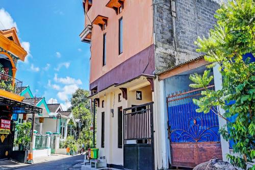 a city street with a building with a blue door at OYO Life 92353 Purnama Syariah Guest House in Blitar