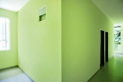 an empty room with green walls and a window at Hotel O Parapat Near Dermaga Ajibata Formerly Pudan Residence 2 in Parapat