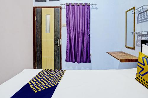 a bedroom with a bed and a purple curtain at Hotel O Sobat Ijen HomestayNearSungai Prengsengan in Rogojampi