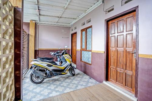 a motorcycle parked in a room next to a door at Hotel O Sobat Ijen HomestayNearSungai Prengsengan in Rogojampi