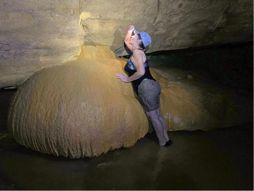 a woman is standing next to a large object at Grutas el Encanto - Casa de la Colina - Ruta a Petén in Rio Dulce