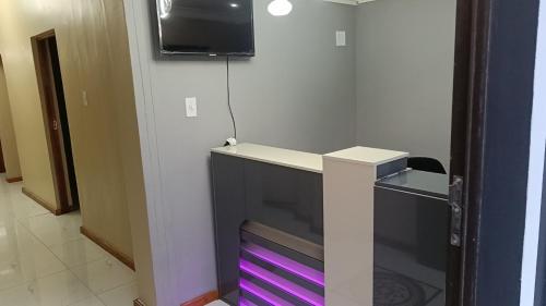 a desk in a room with a tv on a wall at Spring forth guest house in De Grendel
