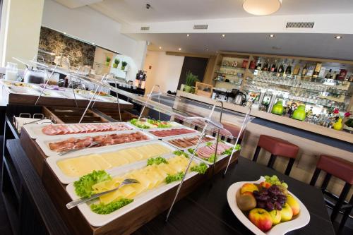 a buffet line with many different types of food at HOTEL PARQÉO im A66 in Gelnhausen