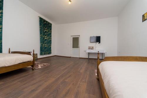 a room with two beds and a desk and a tv at Hotel Emir in Strehaia
