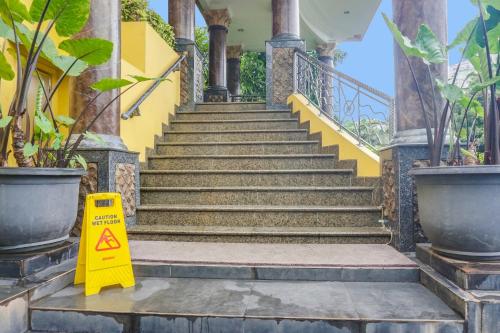 a staircase with a caution sign in front of a building at Townhouse OAK Bi Executive in Jakarta