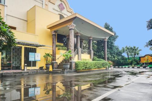 a building in the rain with a reflection in the street at Townhouse OAK Bi Executive in Jakarta