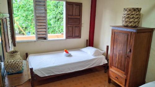 a bedroom with a bed and a dresser and two windows at Posada La Veranera in Arusí