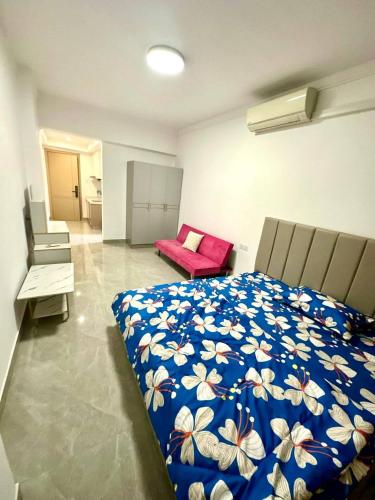 a bedroom with a bed and a red couch at Riverside Apartment in Phnom Penh