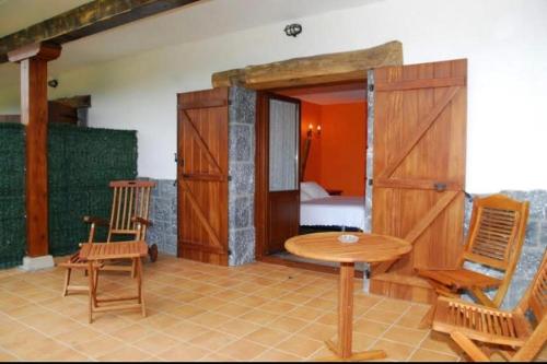 a room with a table and chairs and a bed at casa rural larre aundi in Rentería