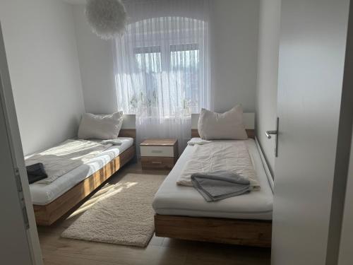 a bedroom with two beds and a window at Wohnungen Beshi Niederthalheim in Vöcklabruck