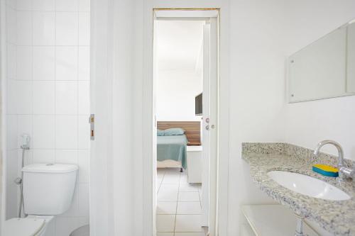 a white bathroom with a sink and a toilet at GB120 Ótimo Apartamento com 3 Suítes - Guarajuba in Monte Gordo