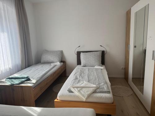 a bedroom with two beds and a mirror at Wohnungen Beshi Niederthalheim in Vöcklabruck