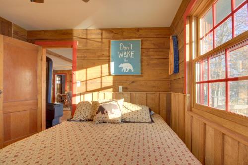 a bedroom with a bed in a room with wooden walls at Cozy Cabin with Private Dock on Fifth Crow Wing Lake in Nevis