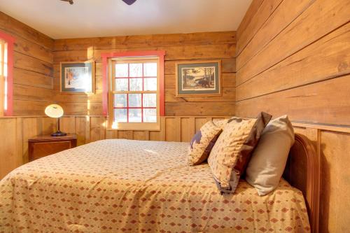 a bedroom with wooden walls and a bed with pillows at Cozy Cabin with Private Dock on Fifth Crow Wing Lake in Nevis