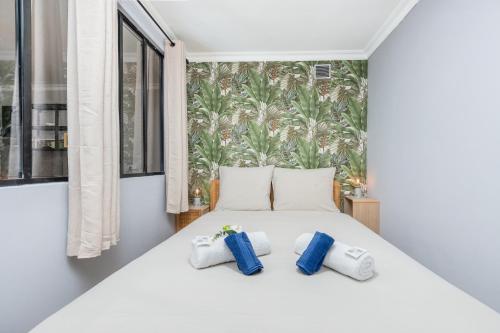 une chambre avec un lit blanc avec deux oreillers dans l'établissement Les tennis, à Roquebrune-Cap-Martin