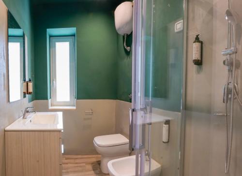 a green bathroom with a toilet and a shower at Rooftop Parthenopeo Contemporary Rooms in Naples
