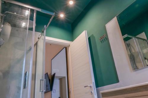 a bathroom with a shower and a green wall at Rooftop Parthenopeo Contemporary Rooms in Naples