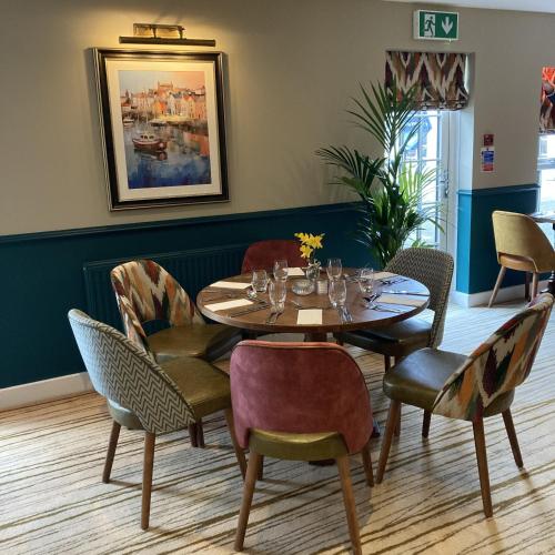 a dining room with a table and chairs at The Britannia Inn & Waves Restaurant in St Austell