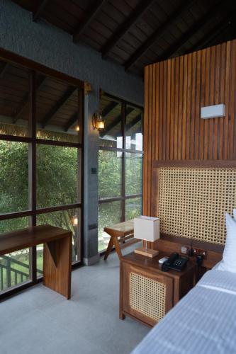 キリンダにあるThe Yala Lodgeのベッドルーム1室(ベッド1台、ランプ付きデスク付)