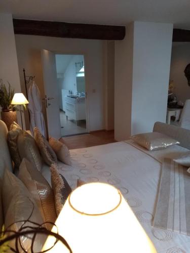 a bedroom with a large bed and a living room at B&B Hof van Vervoering in Voeren