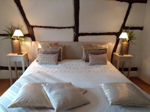 a bedroom with a large white bed with two lamps at B&B Hof van Vervoering in Voeren