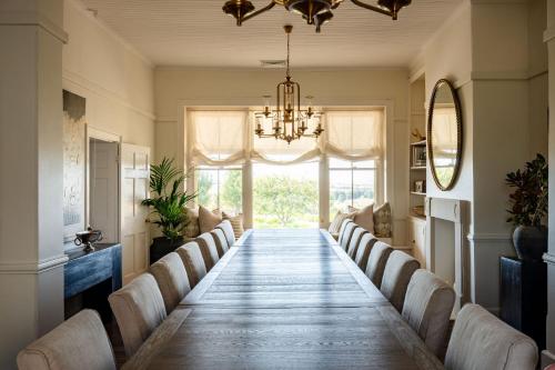 a long dining room table with chairs and a chandelier at Lawsons Estate on Macquarie Farm in Brewongle