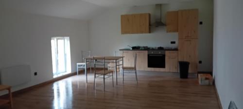 a kitchen with a table and chairs in a room at Gîte du Manoir in Seurre