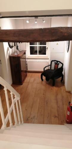 a living room with a chair and a wooden floor at B&B Hof van Vervoering in Voeren