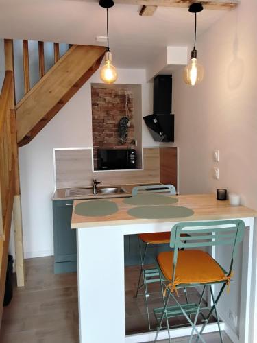 - une cuisine avec un îlot de cuisine avec deux tabourets dans l'établissement Gîte du Jour J, Sainte-Mère-Église centre, à Sainte-Mère-Église