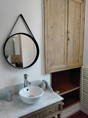 une salle de bain avec un lavabo et un miroir dans l'établissement Gîte du Jour J, Sainte-Mère-Église centre, à Sainte-Mère-Église