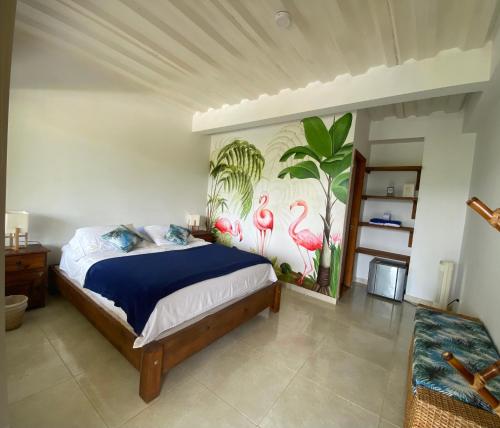 a bedroom with a bed with a mural of flamingos at Tambo Eco Hotel in La Vega