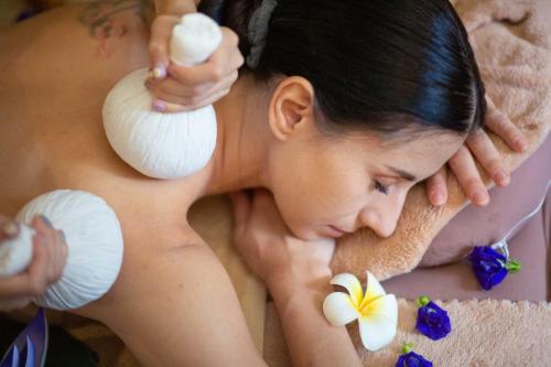a woman getting a massage with seashells on her back at Weingut Schreieck VINOTEL & GUTSHAUS in Sankt Martin
