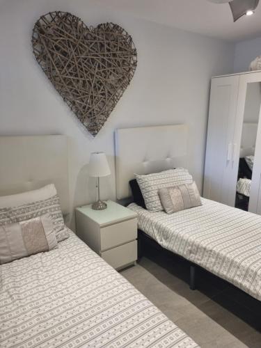 1 dormitorio con 2 camas con un corazón en la pared en Lazydays, en Puerto del Carmen