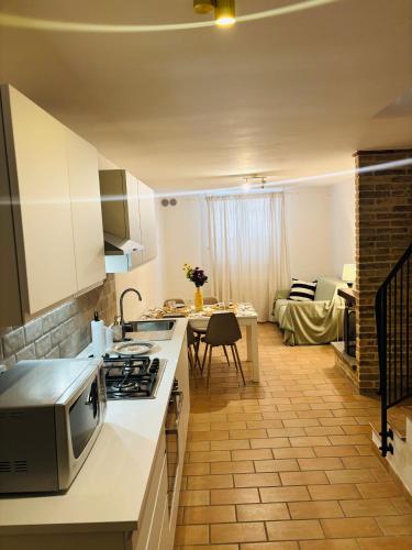 a kitchen with a stove top oven next to a living room at Al Belvedere Apartment II in Atri