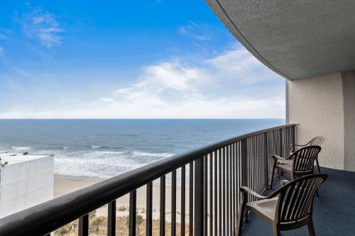 two chairs on a balcony looking out at the ocean at Compass Cove in Myrtle Beach