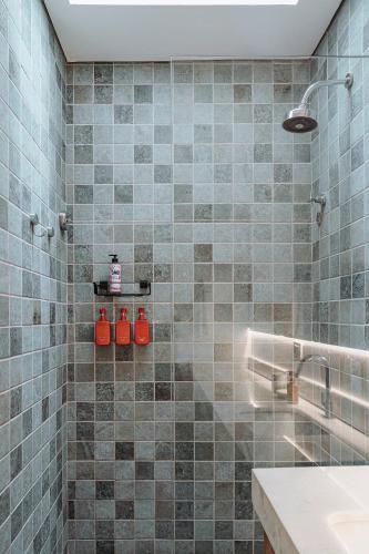 a bathroom with a shower with blue tiles at Vila Sal Boutique Noronha in Fernando de Noronha