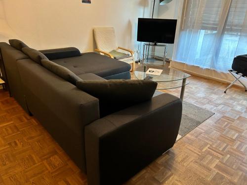 a living room with a couch and a glass table at Münster City Apartment in Münster