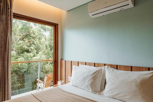 une chambre avec un lit et une grande fenêtre dans l'établissement Vila Sal Boutique Noronha, à Fernando de Noronha