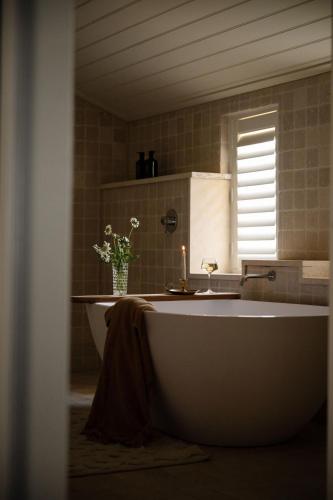 a bathroom with a tub and a vase of flowers at Lawsons Estate on Macquarie Farm in Brewongle