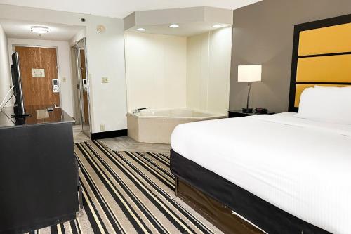 a hotel room with a bed and a bath tub at OYO Townhouse Jackson - Ridgeland in Jackson