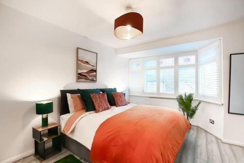 a bedroom with a large bed with colorful pillows at 2BR Near Tottenham Stadium - WiFi - Free Parking in Ponders End