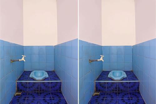 two blue toilets in a bathroom with blue tiles at Hotel O City Kost Syariah in Pangkalpinang